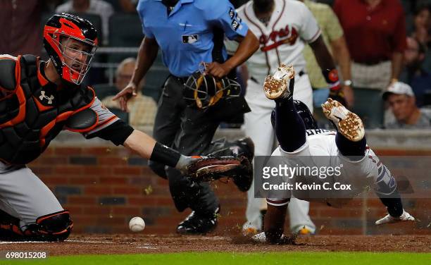 Buster Posey of the San Francisco Giants loses the ball as Johan Camargo of the Atlanta Braves slides safely into homeplate on a double hit by Ender...