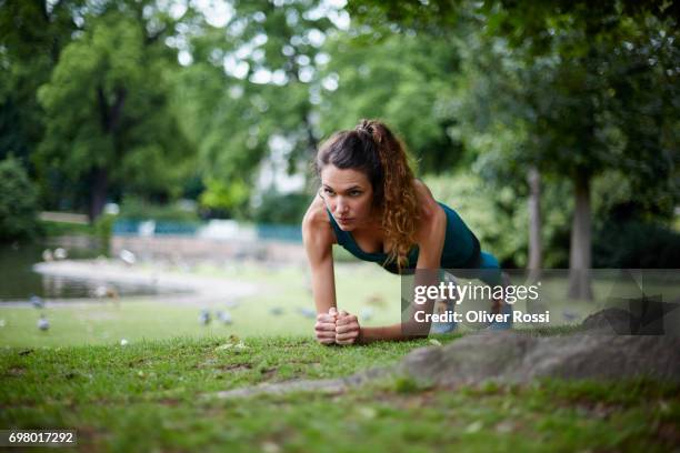 active woman exercising in park - woman fitness focus stock-fotos und bilder