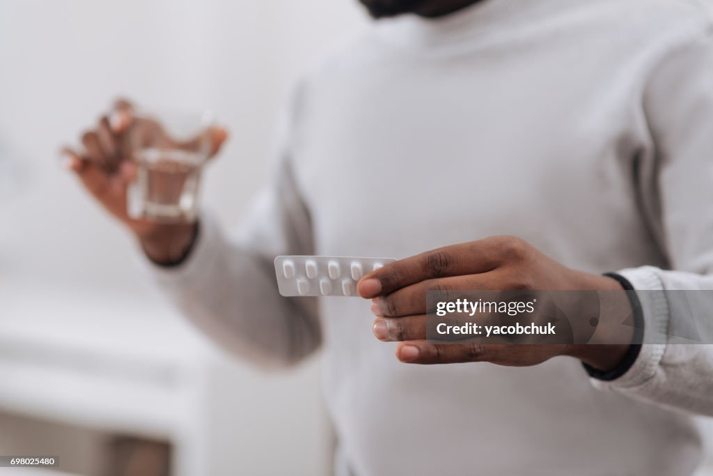 Selective focus of medicine being in hands of a nice adult man