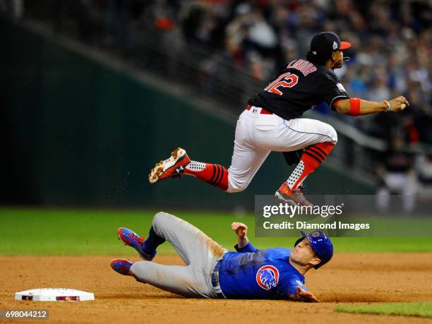 Shortstop Francisco Lindor of the Cleveland Indians leaps over pinch runner Chris Coghlan of the Chicago Cubs, to make an out in the ninth inning of...