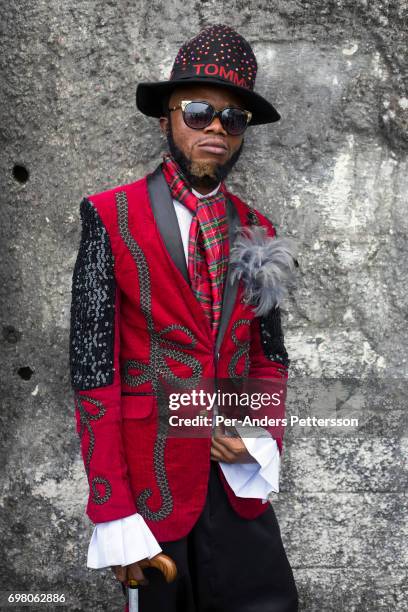 Sapeur poses for a portrait with his designer label clothes while paying his respects to Stervos Nyarcos, the founder of the kitendi religion, which...