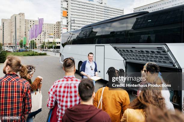 group representative taking a headcount before a bus journey - guia turistico fotografías e imágenes de stock
