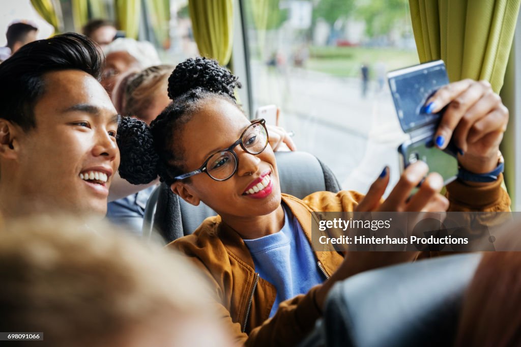 Young Couple Snapping Selfie Together During A Bus Journey