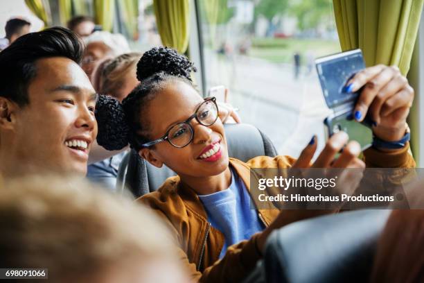 young couple snapping selfie together during a bus journey - coach bus 個照片及圖片檔