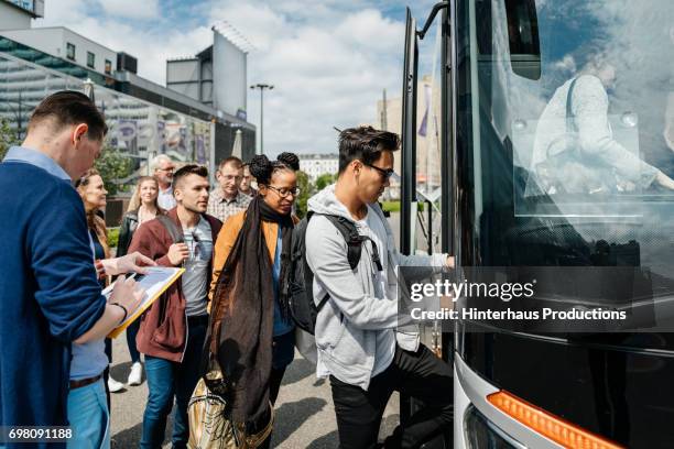 bus is boarded by travellers, ready to start their journey. - black car photos et images de collection