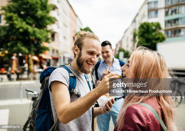 Young Couple Enjoy A Snack Together During A Bus Journey Rest Stop