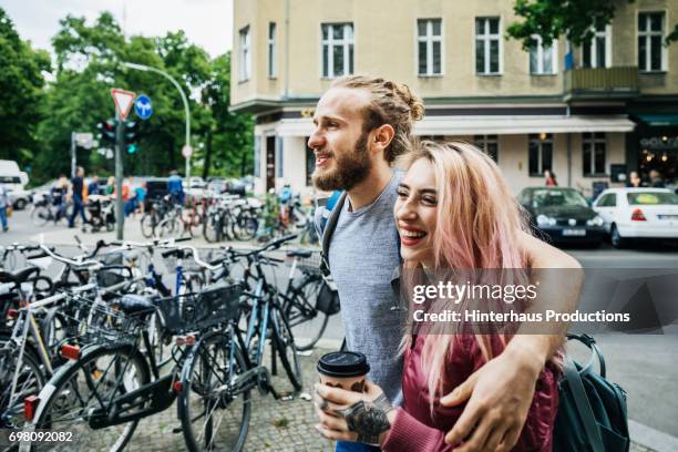 young couple travelling together - walking with bike stock-fotos und bilder