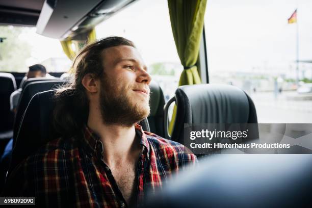 young man relaxing during a bus trip - bus imagens e fotografias de stock