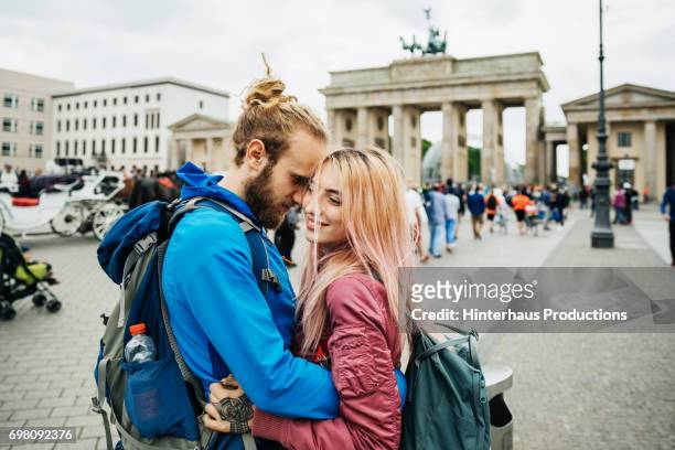 a young couple embrace during a trip to visit brandenburg gate in berlin - past romances ストックフォトと画像