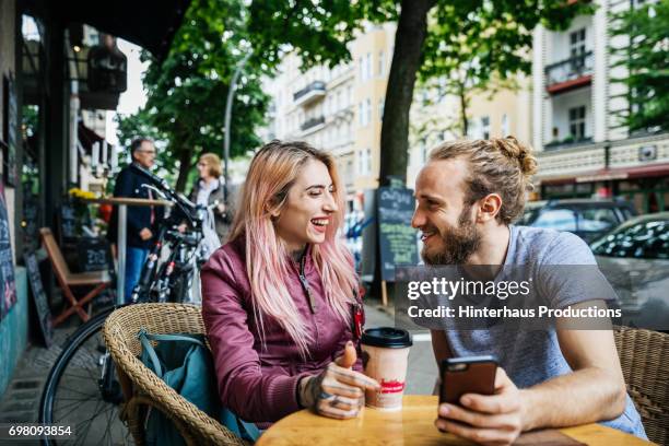 young couple travelling together laughing with each other - couple in cafe man beard coffee stock-fotos und bilder