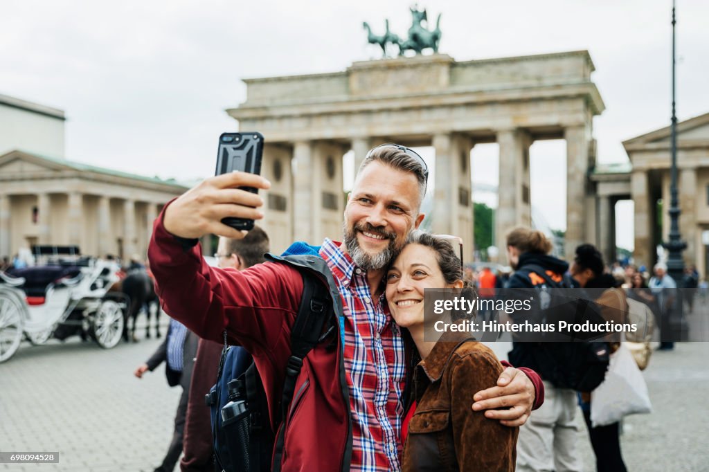 A Mature Couple Take A Selfie Together In Front Of Brandenburg Gate in Berlin