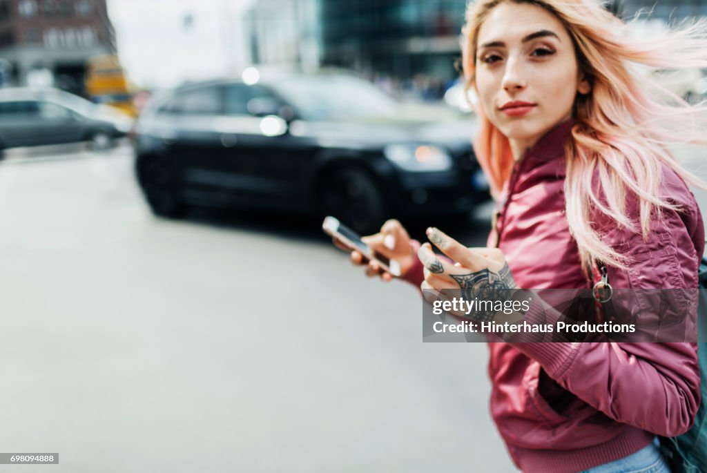 Young Woman Moving Through A City Holding Smartphone