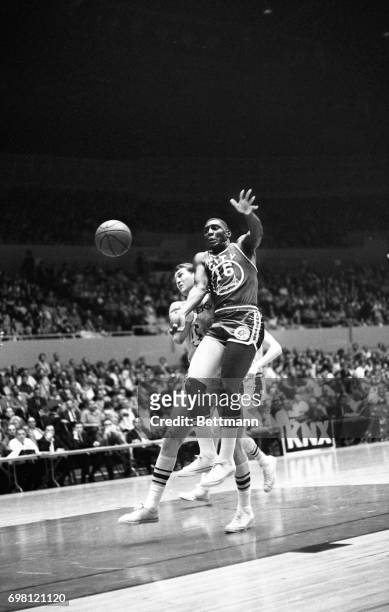 San Francisco's Al Attles passes of to teammate Rudy LaRusso and blocks out Laker Jerry West in the same motion in first period action under the...