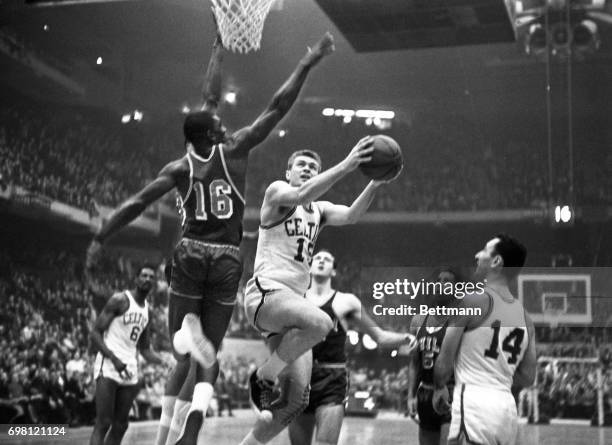 Tommy Heinsohn of the Celtic's, breaks past Al Attles of the Warriors, #16, to lay-up for a basket in the 1st quarter playoff.