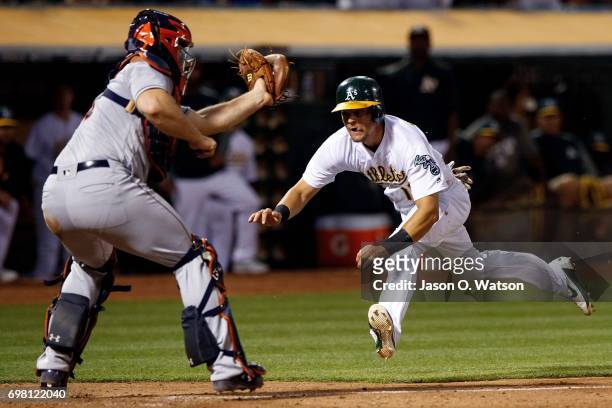 Chad Pinder of the Oakland Athletics is tagged out at home plate by Evan Gattis of the Houston Astros during the sixth inning at the Oakland Coliseum...