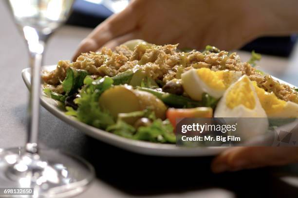salad nicoise presented at dinner table - salad nicoise stock pictures, royalty-free photos & images