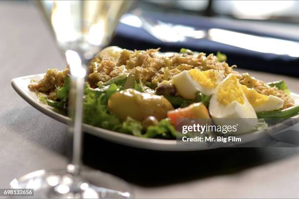 salad nicoise presented at dinner table - salad nicoise stock pictures, royalty-free photos & images