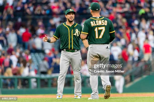 Trevor Plouffe of the Oakland Athletics celebrates with Yonder Alonso after the Oakland Athletics win the game against the Cleveland Indians at...