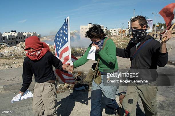 Palestinian youth assists a young woman blinded by tear gas who was part of a small international group of protesters that advanced towards Israeli...