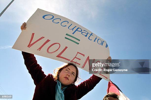 Young woman protester holds up a sign during a demonstration near Yasser Arafats headquarters February 5, 2002 in the West Bank town of Ramallah. The...