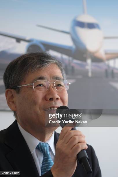 Shunichi Miyanaga, Mitsubishi Heavy Industries' President and Chief Executive Officer, attends a news conference in front an image of the third...