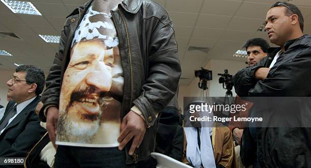 Yasser Arafat supporter wraps himself in a poster of the Palestinian President during a meeting with Arafat at his office February 8, 2002 in the...