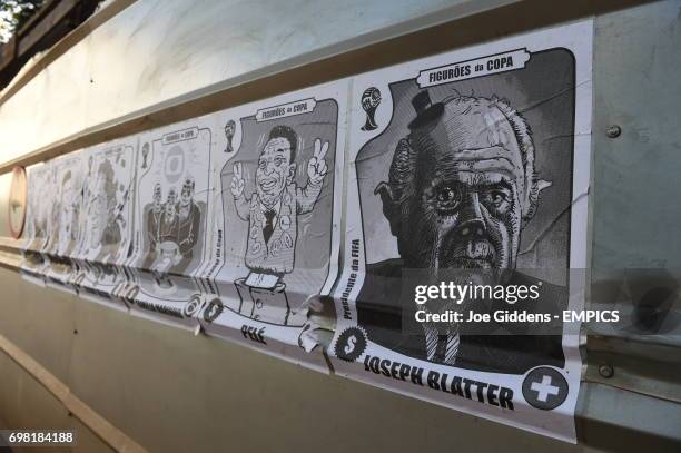 View of posters on a wall showing caricatures of various football related celebrities including Ricardo Texeira, Ronaldo, Jerome Valcke, Familia...