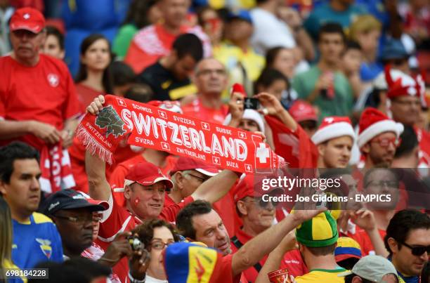 Switzerland fan holds up a scarf in support of his team in the stands