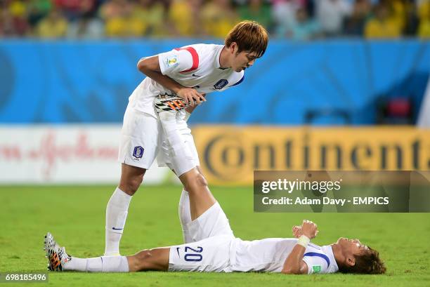 South Korea's Hong Jeong-Ho receives treatment for cramp from team-mate Kim Young-Gwon