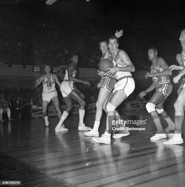 Tom Meschery of the Warriors looks for somebody to pass off to as he's harassed by Clyde Lovellette of St. Louis' Hawks during 1st quarter here 12/6.