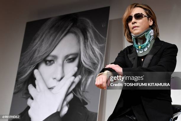 Yoshiki from the Japanese band "X Japan" wears a neck brace while attending a press conference for his world tour concert in Tokyo on June 20, 2017....