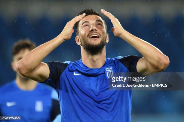 Greece's Andreas Samaris reacts as rain begins to fall during a training session at Arena das Dunas in Natal