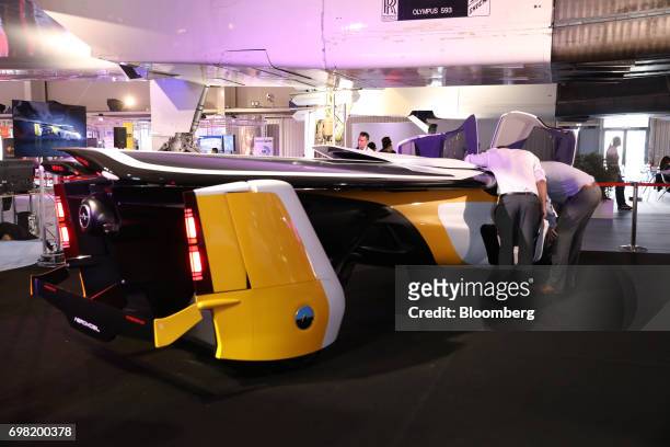Attendees inspect an AeroMobil flying car as it stands on display during the 53rd International Paris Air Show at Le Bourget, in Paris, France, on...