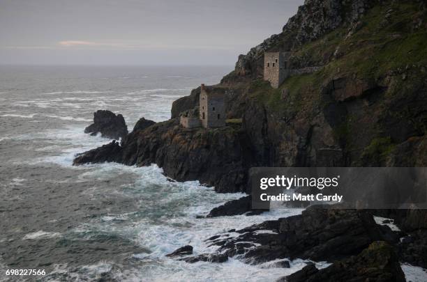 The sun sets in front of the crowns engine houses at the old tin mining works at Botallack near St Just that was used as a location in the BBC's...