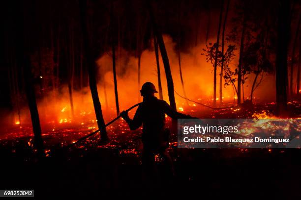 Firefighter from the National Republican Guard GIPS works on a fire in a forest after a wildfire took dozens of lives on June 19, 2017 near Pedrogao...