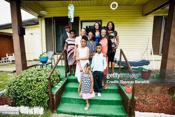 portrait of smiling multigenerational family standing of front porch of home - südstaaten stock-fotos und bilder