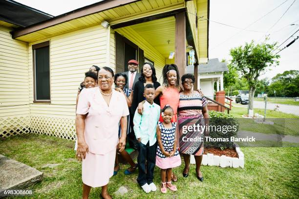 portrait of smiling grandmother standing with family in front of house before going to church - beautiful granny bildbanksfoton och bilder