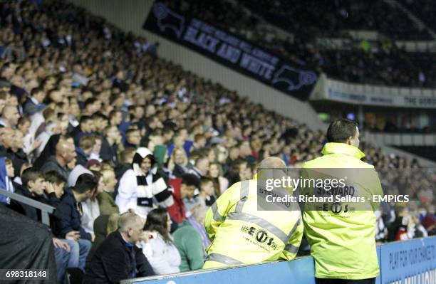 Stewards look over fans in the stands