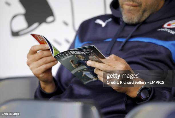 Reading staff member reads the match day program