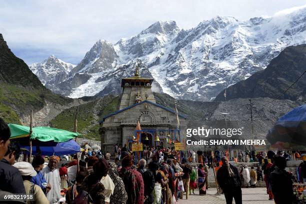 In this photograph taken on June 16 Indian Hindu devotees pay respects at the restored Kedarnath Temple that was hit during the deadly 2013 North...