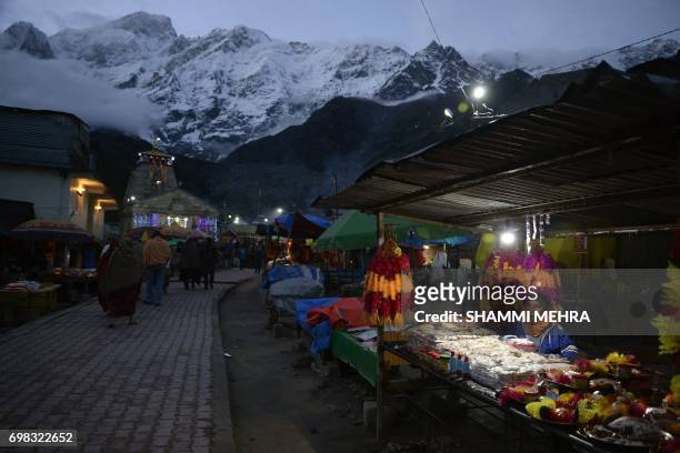 In this photograph taken on June 15 an Indian shopkeeper sits in a stall set up for Hindu devotees paying respects at the restored Kedarnath Temple...