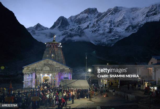 In this photograph taken on June 15 Indian Hindu devotees pay respects at the restored Kedarnath Temple that was hit during the deadly 2013 North...