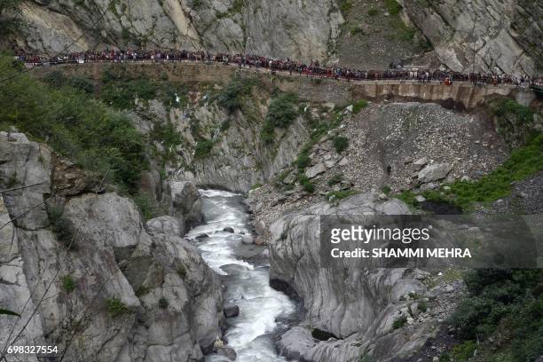 In this photograph taken on June 15 Indian Hindu devotees walk at the restored Kedarnath Temple that was hit during the deadly 2013 North India...