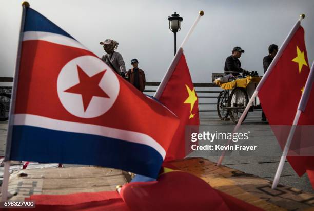 Chinese vendors sell North Korea and China flags on the boardwalk next to the Yalu river in the border city of Dandong, Liaoning province, northern...