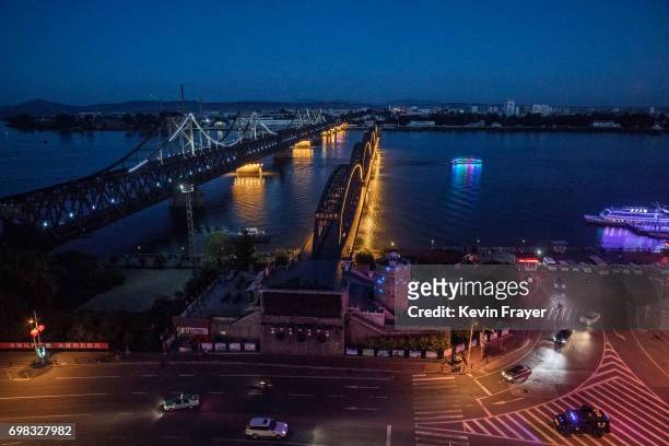 The "Friendship Bridge", left, and "Broken Bridge" are seen as a train crosses on the Yalu river from the border city of Dandong, Liaoning province,...