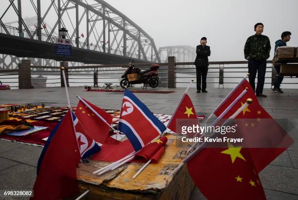 Chinese vendors sell North Korea and China flags on the boardwalk next to the Yalu river in the border city of Dandong, Liaoning province, northern...