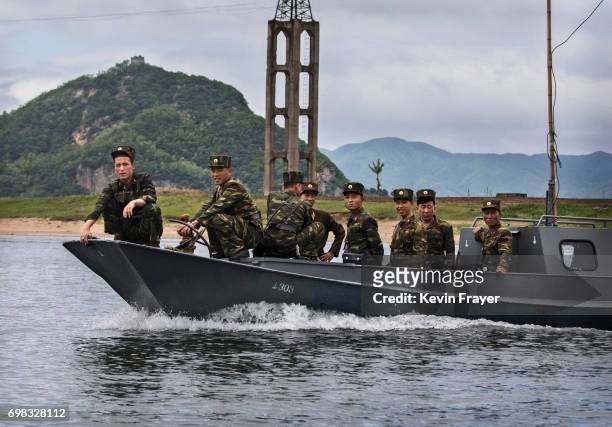 North Korean soldiers ride on a boat used as a local ferry as they cross the Yalu river north of the border city of Dandong, Liaoning province,...