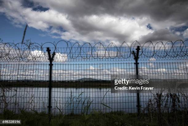 Fence with razor wire is seen protecting the border on the Yalu river north of the border city of Dandong, Liaoning province, northern China across...
