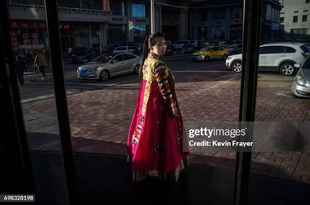 North Korean restaurant worker tries to attract customers in the border city of Dandong, Liaoning province, northern China across the Yalu River from...