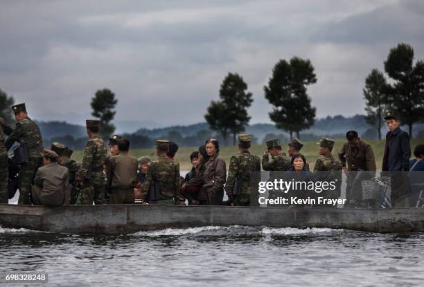 North Koreans ride on a boat used as a local ferry as they cross the Yalu river north of the border city of Dandong, Liaoning province, northern...